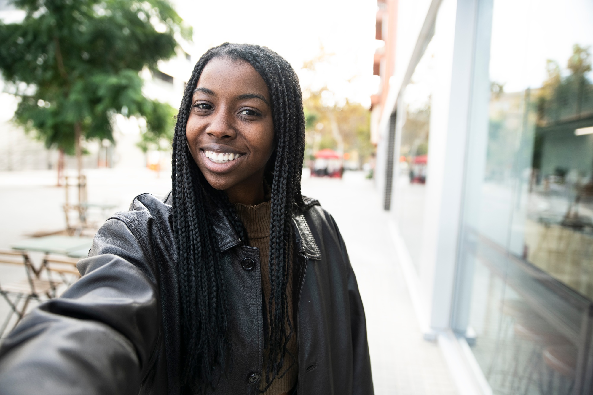 happy young woman smiling taking a selfie portrait in the city - portrait of young afro american