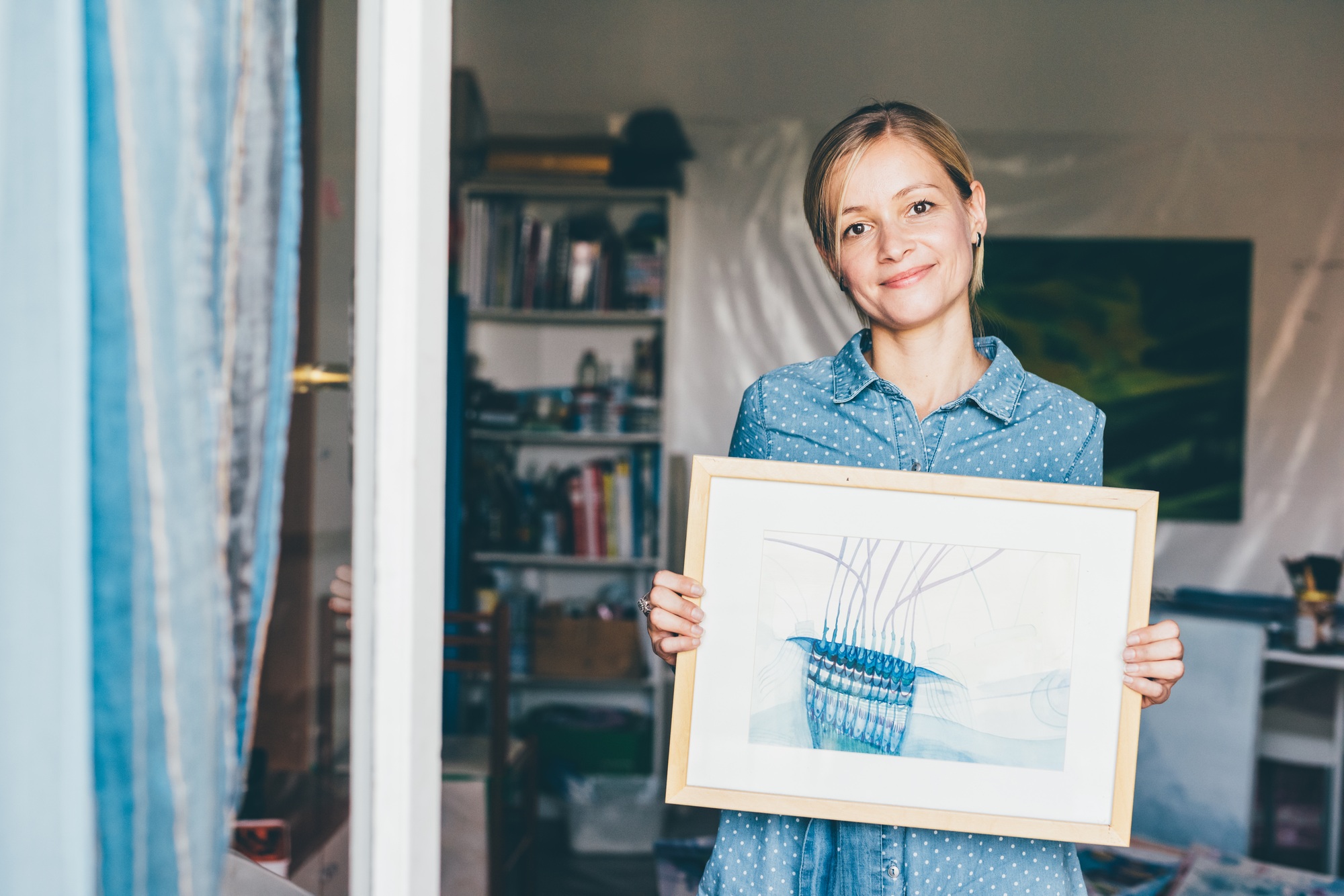 Young woman showing painting framed